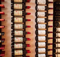 Rows of red wine hung on the wall, on their side.